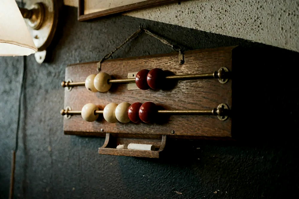 Un vecchio segnapunti di legno a palline appeso al muro della sala